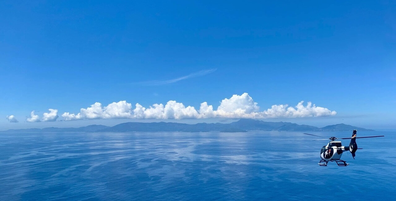 helicopter flying over Seychelles islands and turquoise ocean